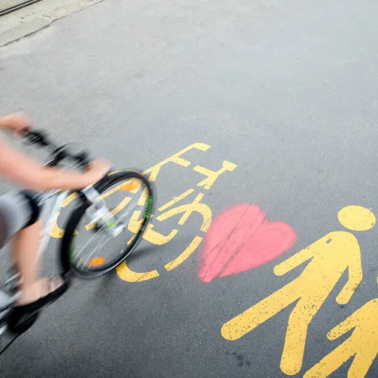 Velofahrerin fährt über Piktogramme auf der Strasse
