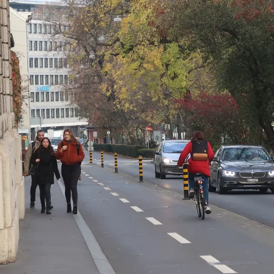 Menschen auf Trottoir neben Veloweg
