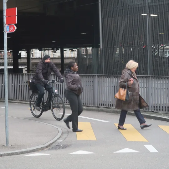 Menschen überqueren Strasse vor Velofahrer