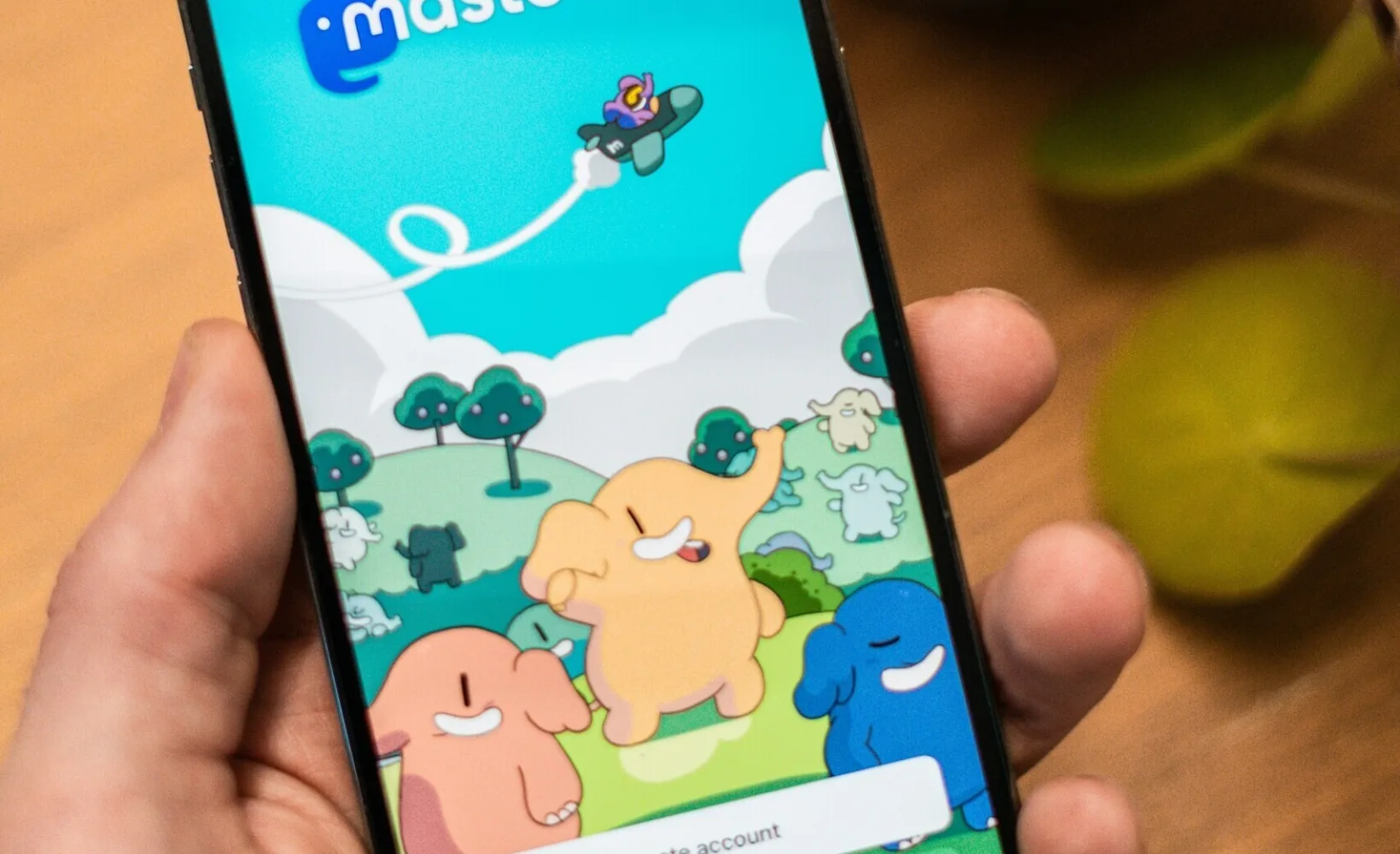 Mobiltelefon in einer Hand vor einer Pflanze