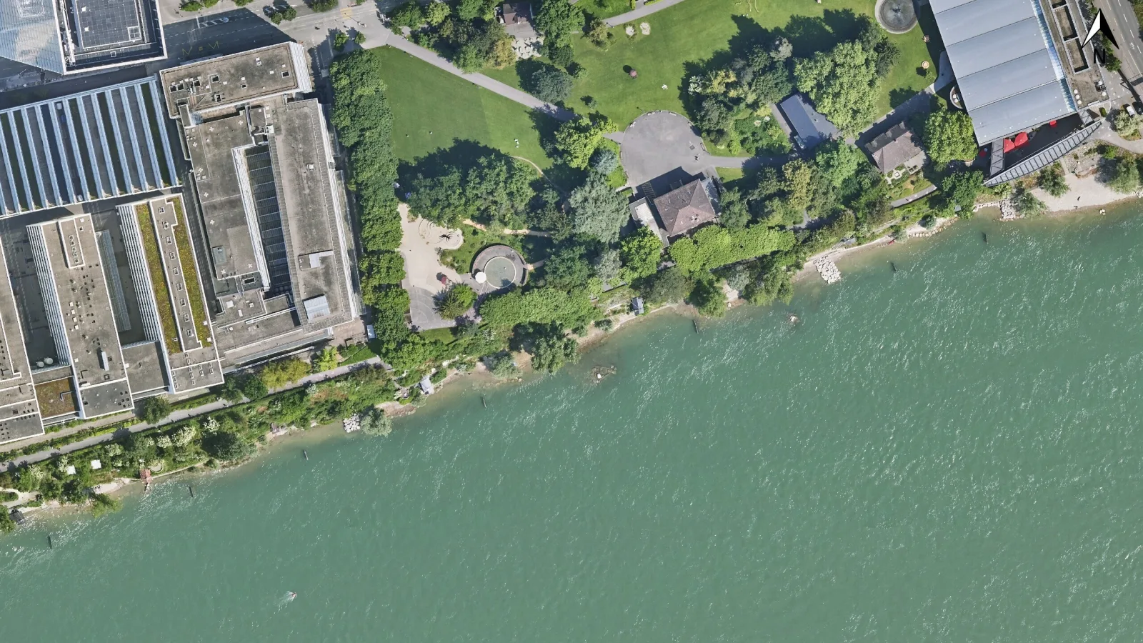 Orthofoto der Solitudepromenade: Unten ist der türkise Rhein zu sehen, oben die Gartenanlage der Solitude-Promenade, links die Roche-Gebäude