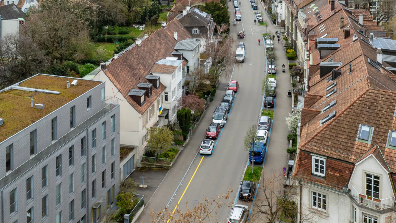 Blick aus Vogelperspektive in die Wettsteinallee zwischen Riehenring und Wettsteinplatz. Die Strasse ist geprägt von Parkplätzen in der blauen Zone.