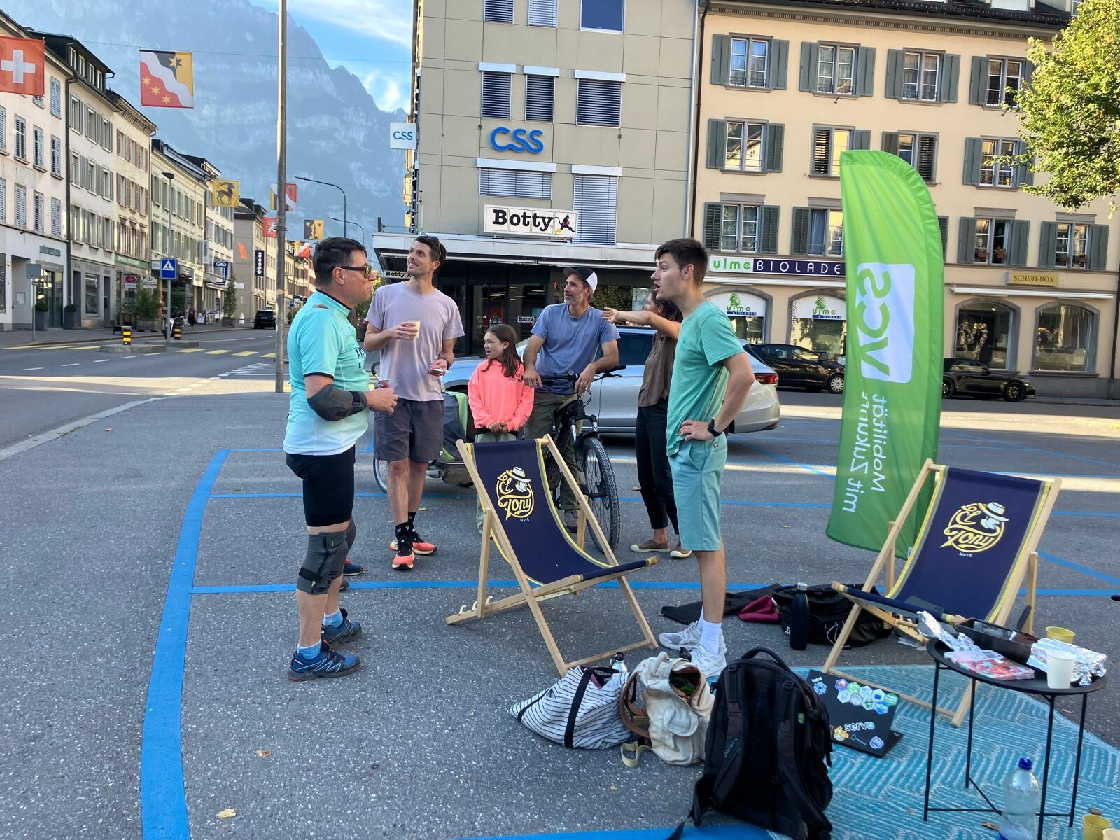 Mehrere Bescuher stehen und diskutieren miteinander auf den zwei Parkplätzen