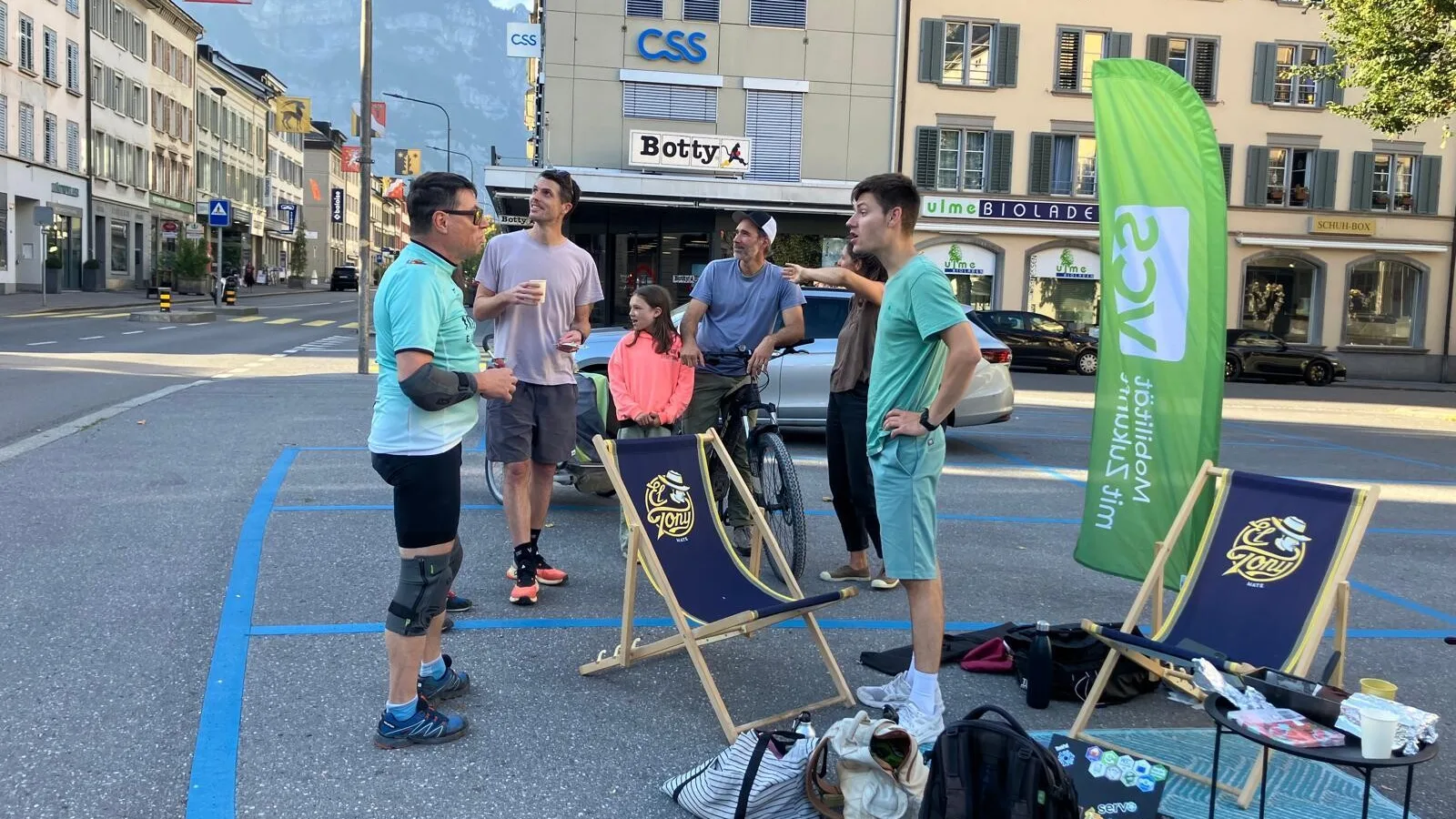 Mehrere Bescuher stehen und diskutieren miteinander auf den zwei Parkplätzen