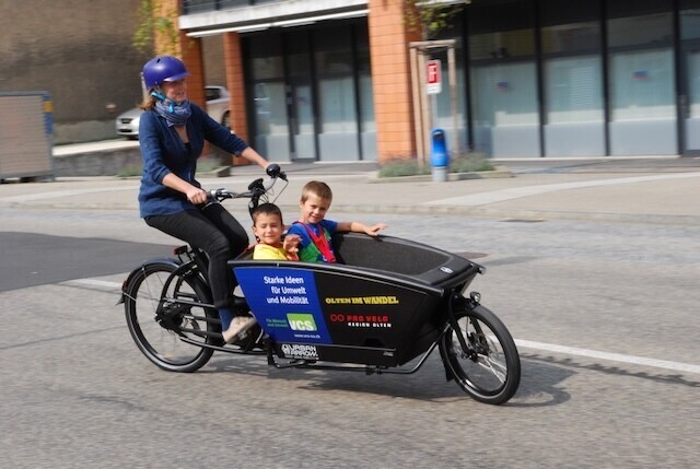 Cargovelo mit einer Frau und zwei Kindern