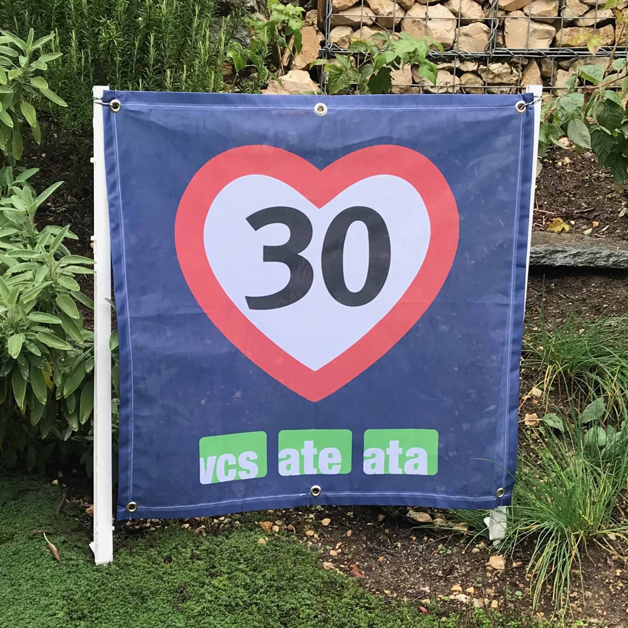 Tempo-30-Fahne in einem Garten