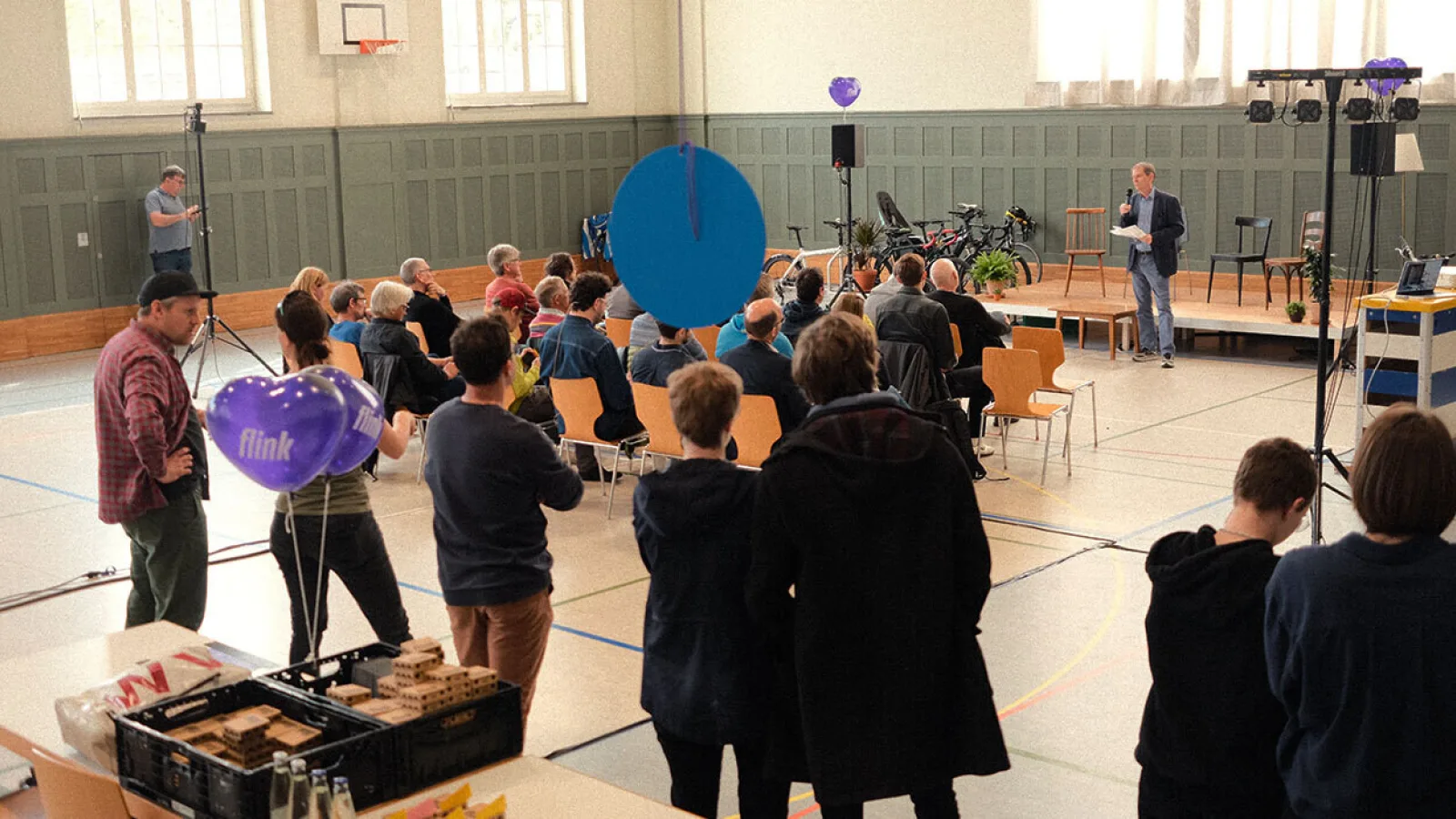 Menschen in einer Halle hören Sprecher zu