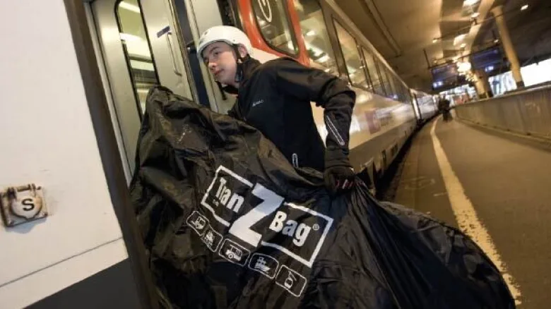 Velofahrer trägt Velo in Tranzbag in Zug