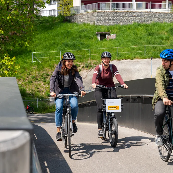 3 Leute auf Velos auf einer Velobrücke