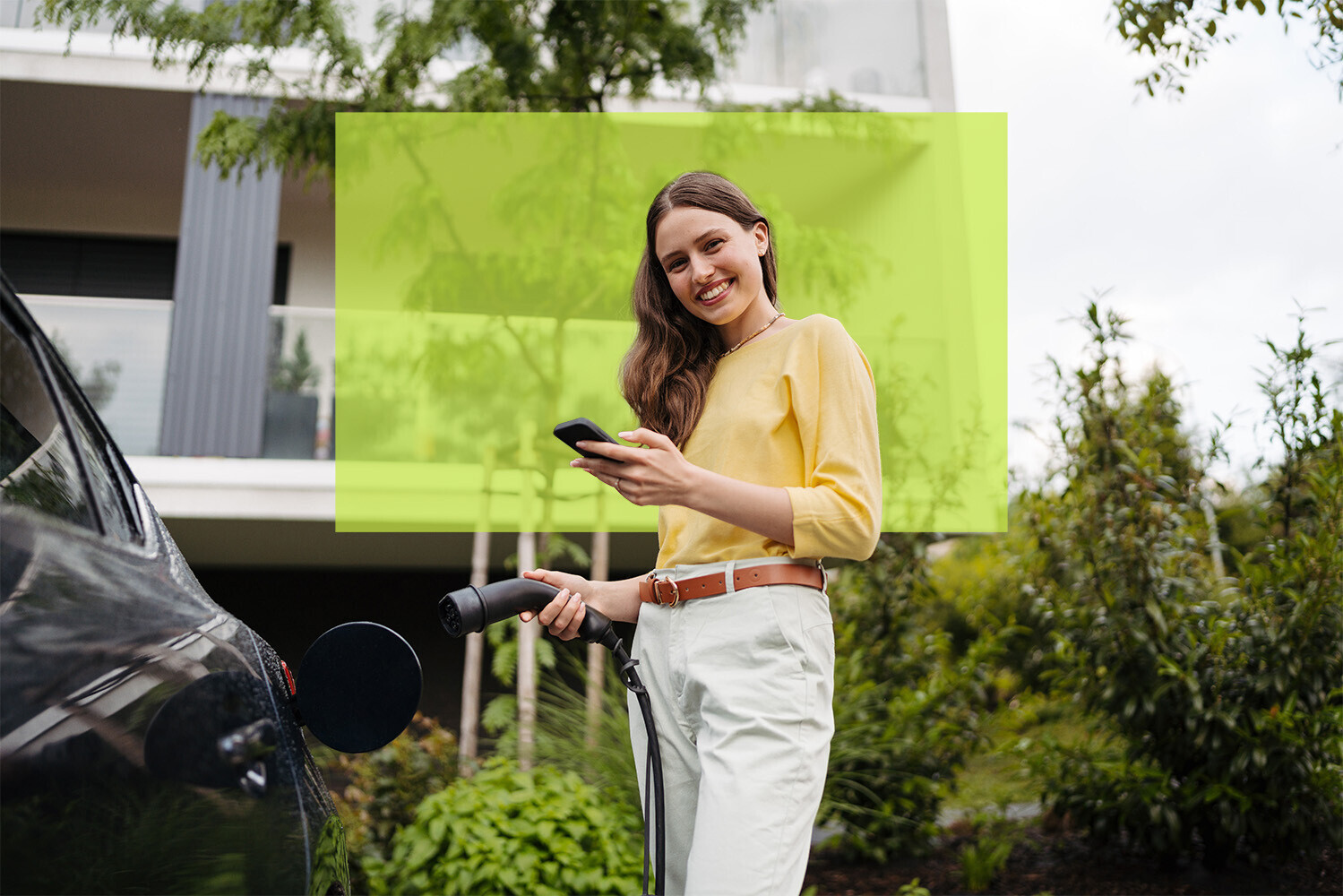 Frau lädt Elektroauto