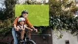 Frau auf Velo mit Kind in Kindersitz
