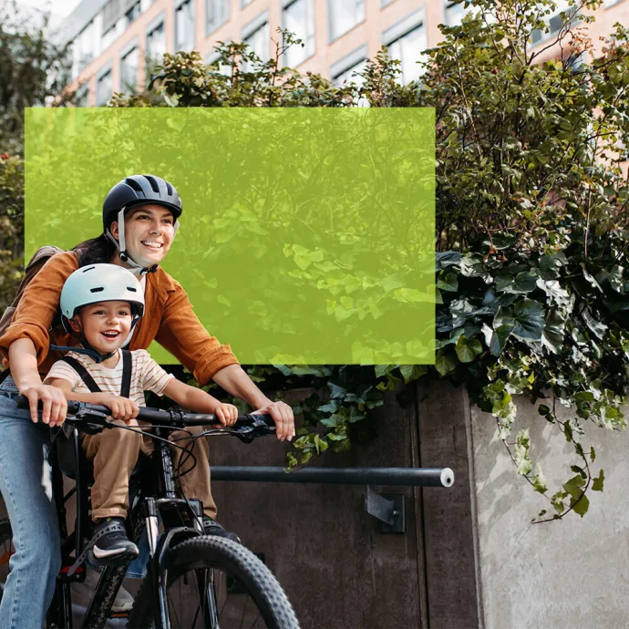 Frau auf Velo mit Kind in Kindersitz